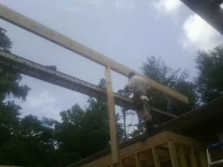 Carpenter setting a ridge beam over a new addition frame — Ice Dam Removal by Roofing Brothers in Sandy Hook