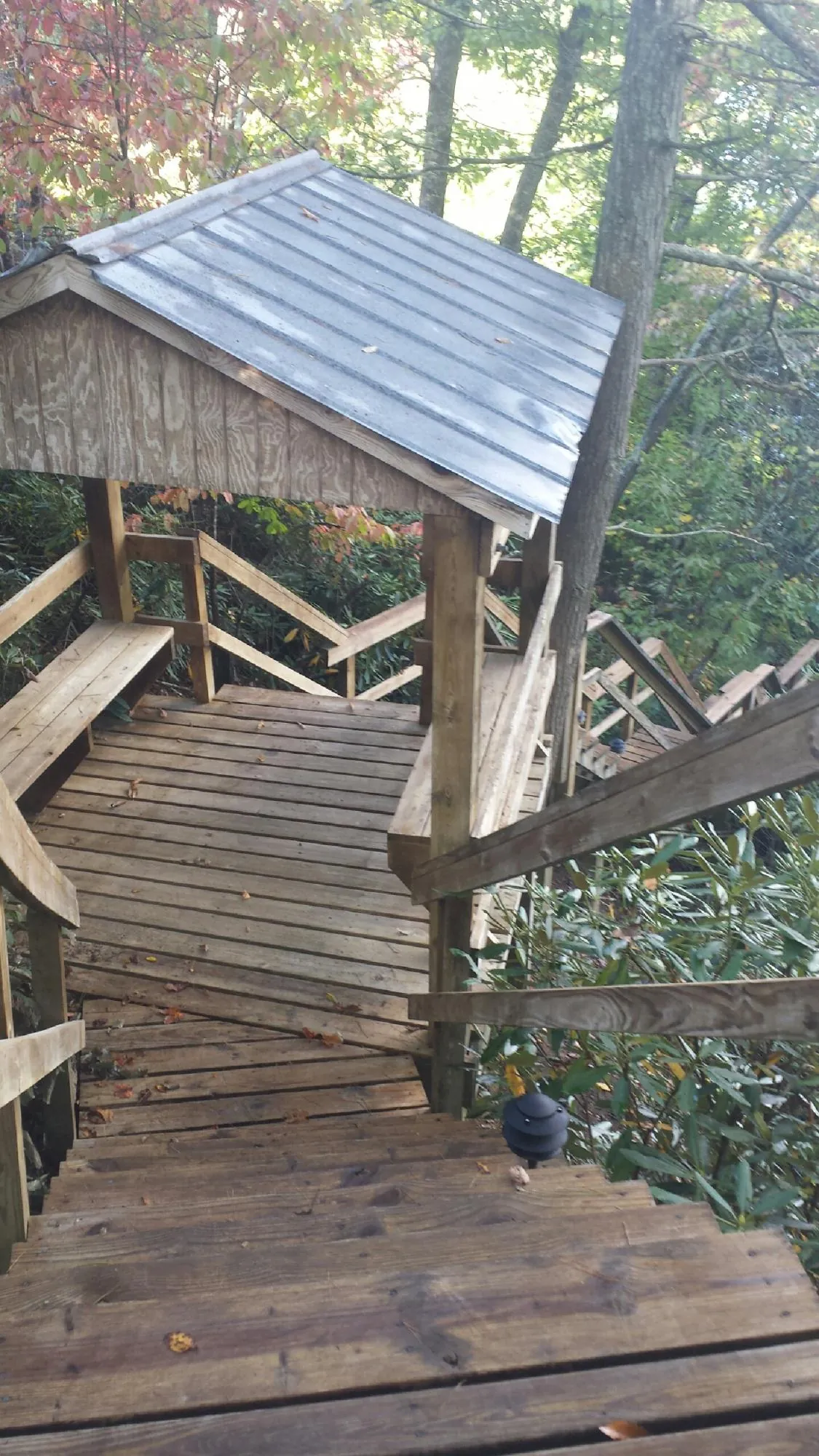 Metal roofed shelter over wooden steps on a wooded walkway — Skylight Repair & Installation work by our crew in Sandy Hook